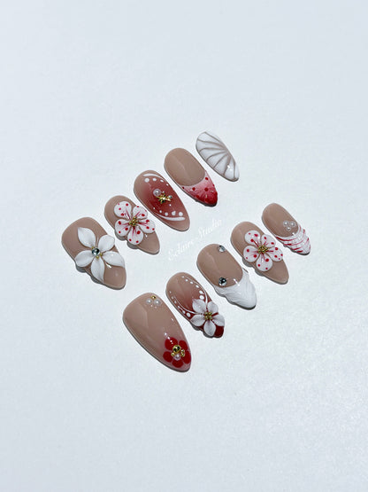 Rouge press-on nails with red linework and 3D white florals on a nude base – Éclaire Studio