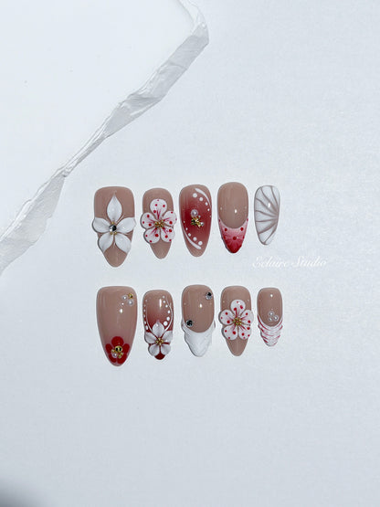 Rouge press-on nails with red linework and 3D white florals on a nude base – Éclaire Studio