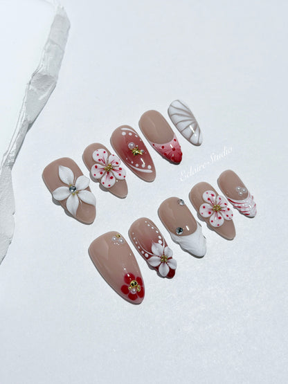Rouge press-on nails with red linework and 3D white florals on a nude base – Éclaire Studio