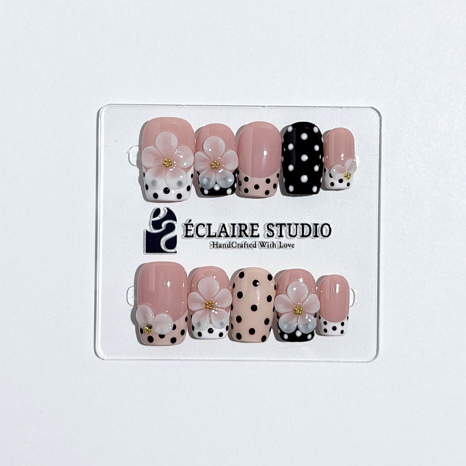 Eclaire Nail Studio 3D Floral Polka dot pink base with alternating black and white polka dot French tips, and hand-sculpted 3D frosted white flowers with gold bead centers, Medium Square