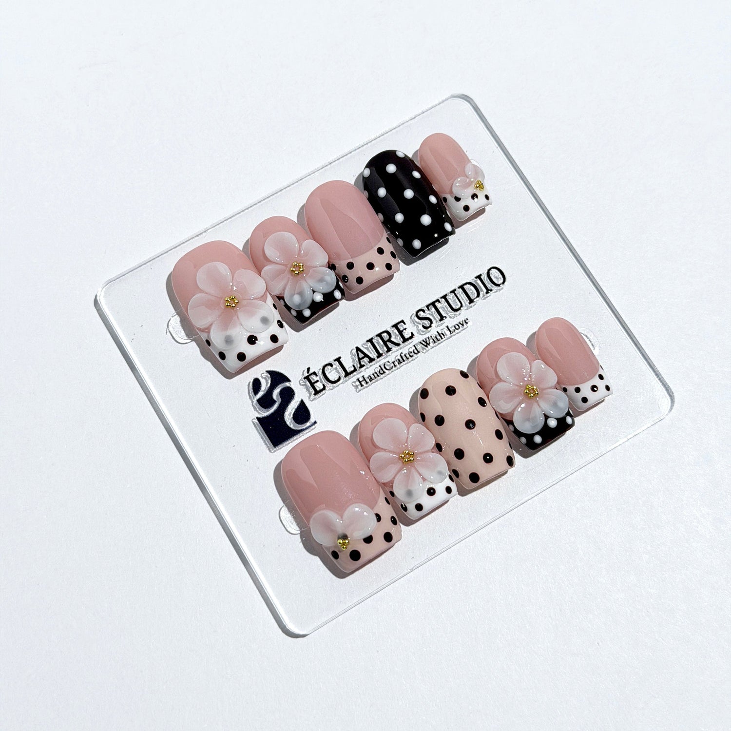 Eclaire Nail Studio 3D Floral Polka dot pink base with alternating black and white polka dot French tips, and hand-sculpted 3D frosted white flowers with gold bead centers, Medium Square
