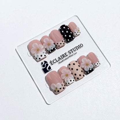 Eclaire Nail Studio 3D Floral Polka dot pink base with alternating black and white polka dot French tips, and hand-sculpted 3D frosted white flowers with gold bead centers, Medium Square
