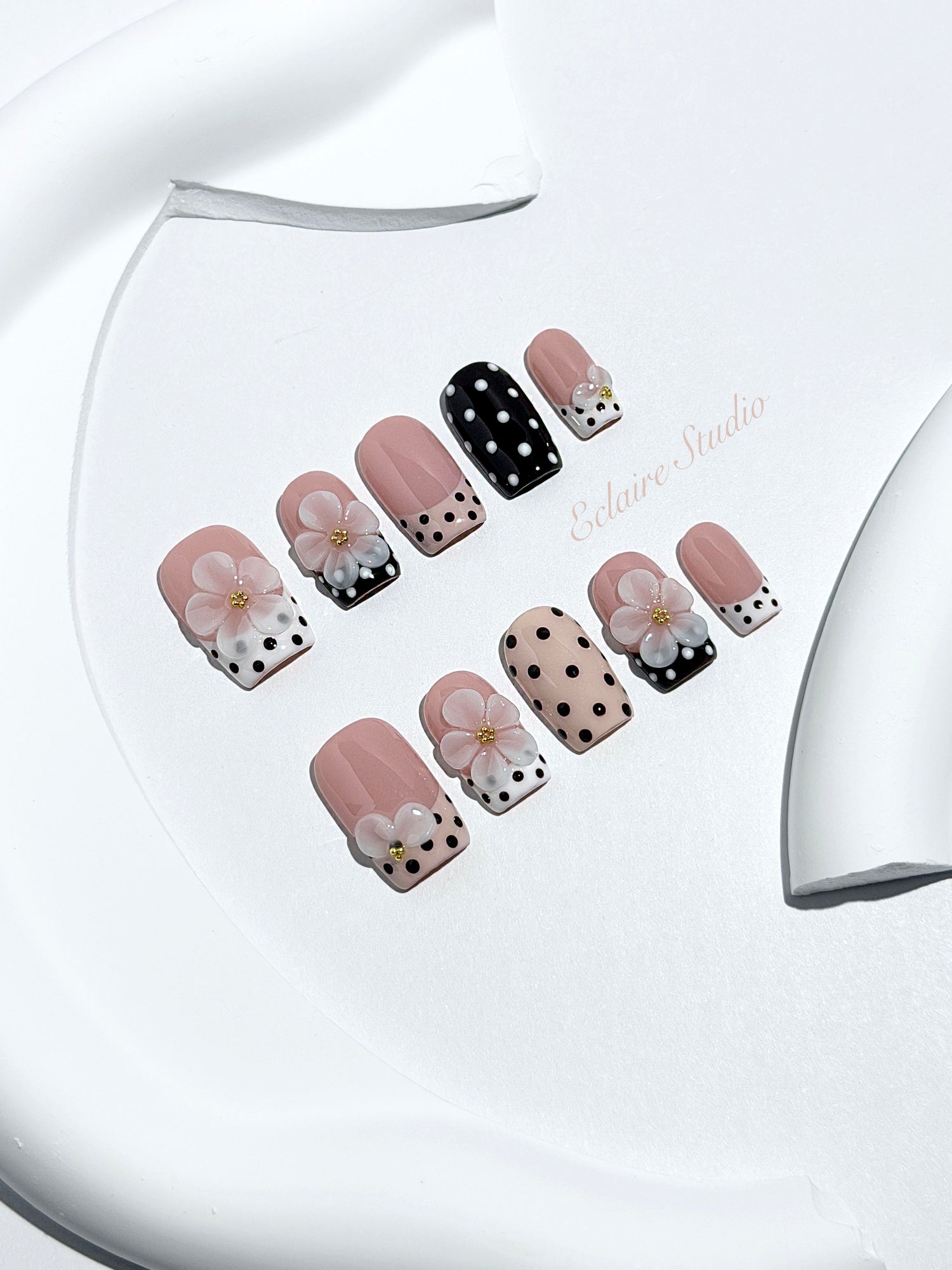 Eclaire Nail Studio 3D Floral Polka dot pink base with alternating black and white polka dot French tips, and hand-sculpted 3D frosted white flowers with gold bead centers, Medium Square