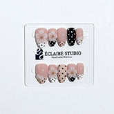 Eclaire Nail Studio 3D Floral Polka dot pink base with alternating black and white polka dot French tips, and hand-sculpted 3D frosted white flowers with gold bead centers, Short Almond
