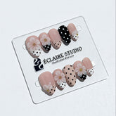 Eclaire Nail Studio 3D Floral Polka dot pink base with alternating black and white polka dot French tips, and hand-sculpted 3D frosted white flowers with gold bead centers, Short Almond