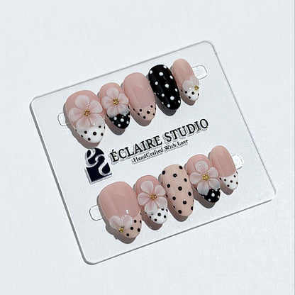 Eclaire Nail Studio 3D Floral Polka dot pink base with alternating black and white polka dot French tips, and hand-sculpted 3D frosted white flowers with gold bead centers, Short Almond