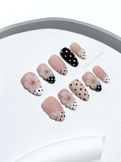 Eclaire Nail Studio 3D Floral Polka dot pink base with alternating black and white polka dot French tips, and hand-sculpted 3D frosted white flowers with gold bead centers, Short Almond