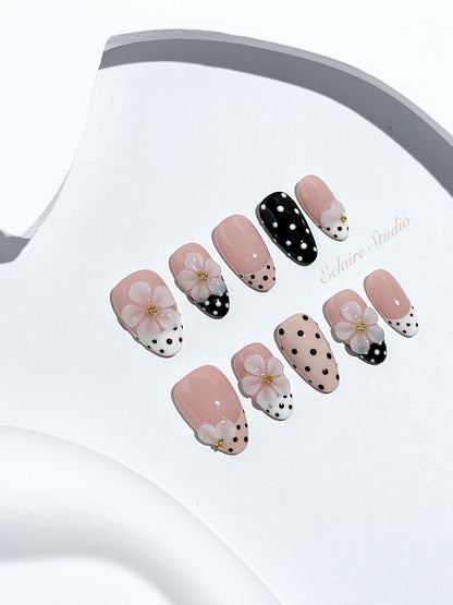 Eclaire Nail Studio 3D Floral Polka dot pink base with alternating black and white polka dot French tips, and hand-sculpted 3D frosted white flowers with gold bead centers, Short Almond
