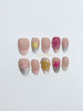 Eclaire Studio 3D Summer short almond press-on nails with sheer nude bases, sparkling silver cat-eye magnetic French tips, hand-painted colorful starfish, and pink 3D sculpted seashells.