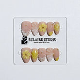 Eclaire Studio Yellow Summer short almond press-on nails featuring a sheer nude base with yellow French tips, hand-sculpted 3D flowers, frosted 3D seashells
