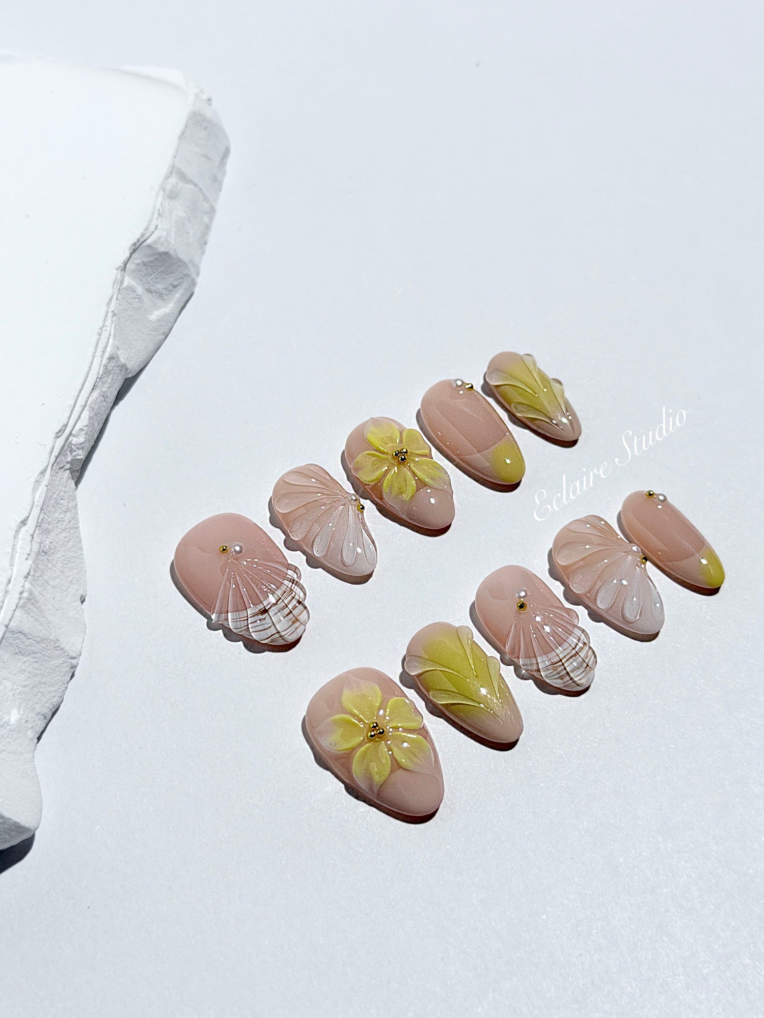 Eclaire Studio Yellow Summer short almond press-on nails featuring a sheer nude base with yellow French tips, hand-sculpted 3D flowers, frosted 3D seashells