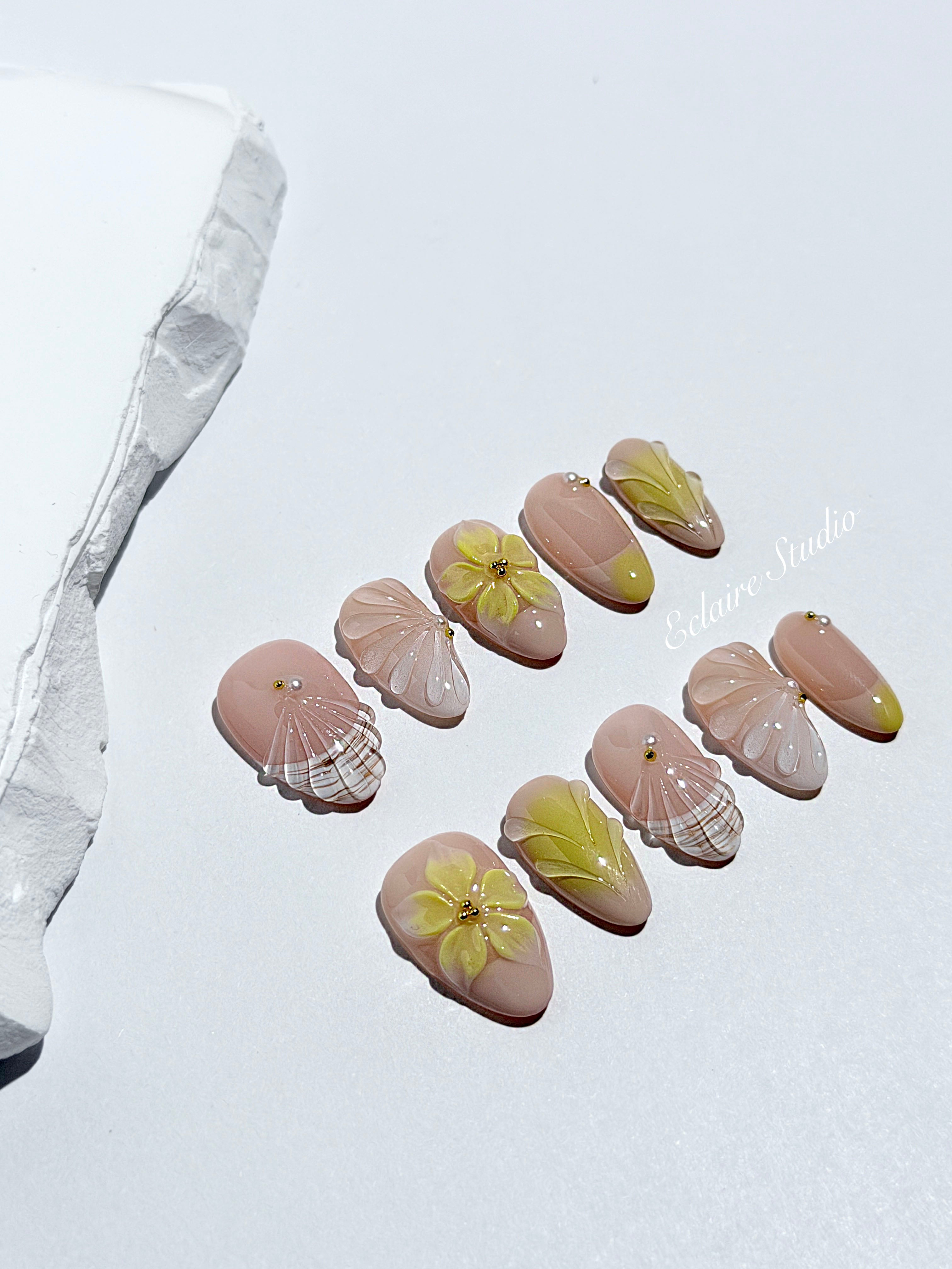 Eclaire Studio Yellow Summer short almond press-on nails featuring a sheer nude base with yellow French tips, hand-sculpted 3D flowers, frosted 3D seashells