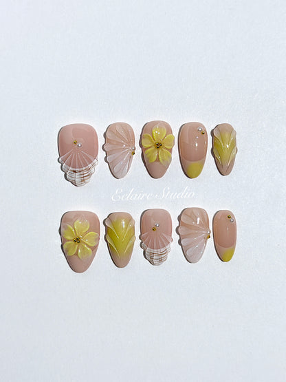 Eclaire Studio Yellow Summer short almond press-on nails featuring a sheer nude base with yellow French tips, hand-sculpted 3D flowers, frosted 3D seashells