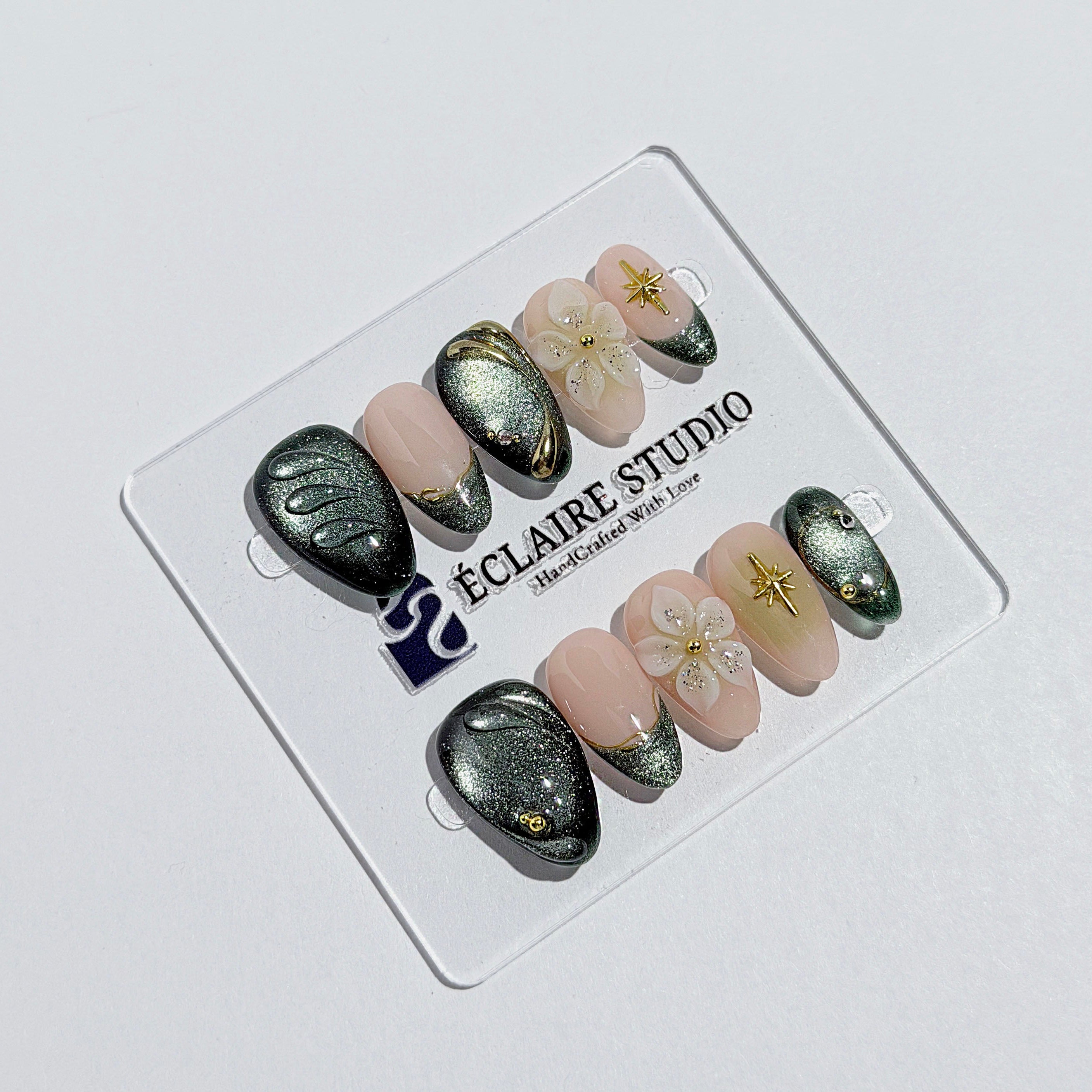 Bali Escape almond press-on nails with emerald cat-eye shimmer, 3D frosted flowers and gold accents – Éclaire Studio