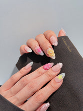 Eclaire Studio 3D Summer short almond press-on nails with sheer nude bases, sparkling silver cat-eye magnetic French tips, hand-painted colorful starfish, and pink 3D sculpted seashells.