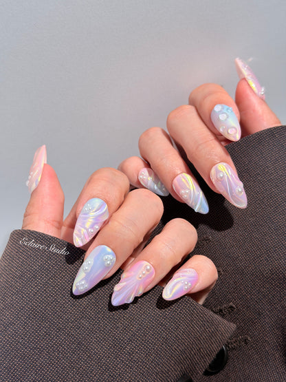 Handcrafted luxury press-on nails in a medium almond shape featuring an iridescent multi-toned glazed finish with 3D sculpted shell ridges and delicate mini pearls.