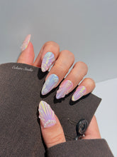 Handcrafted luxury press-on nails in a medium almond shape featuring an iridescent multi-toned glazed finish with 3D sculpted shell ridges and delicate mini pearls.