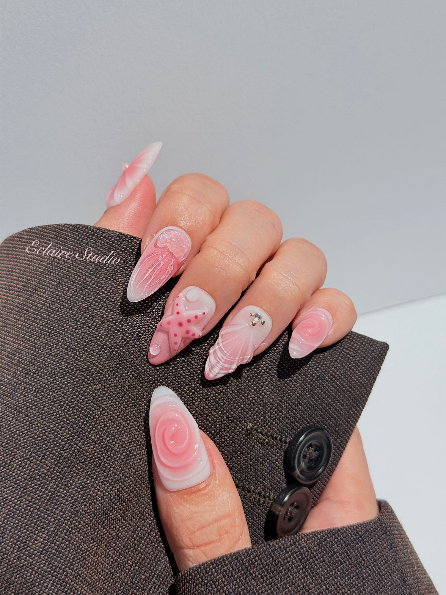 Luxury press-on nails featuring a soft blush pink ombre base with white French tips, a translucent 3D jellyfish, a sculpted pink starfish, and a clear 3D glass flower with a pearl center.