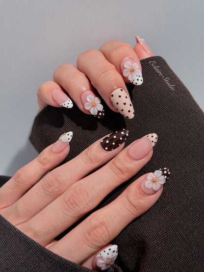 Eclaire Nail Studio 3D Floral Polka dot pink base with alternating black and white polka dot French tips, and hand-sculpted 3D frosted white flowers with gold bead centers, Short Almond