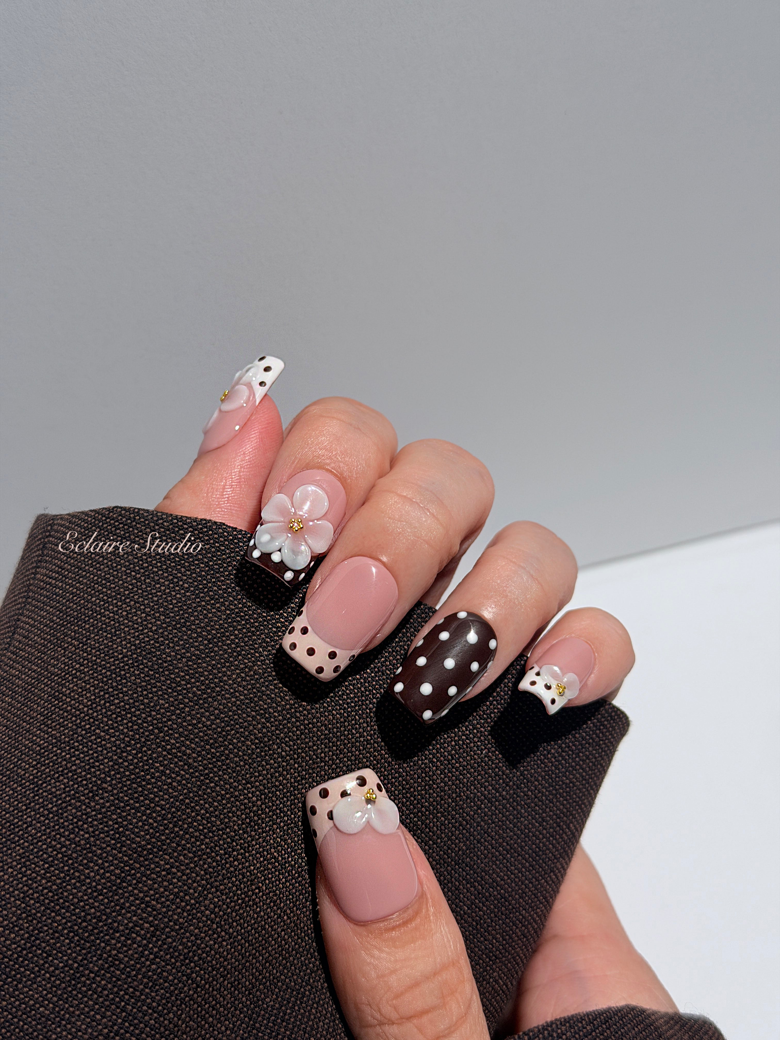 Eclaire Nail Studio 3D Floral Polka dot pink base with alternating black and white polka dot French tips, and hand-sculpted 3D frosted white flowers with gold bead centers, Medium Square