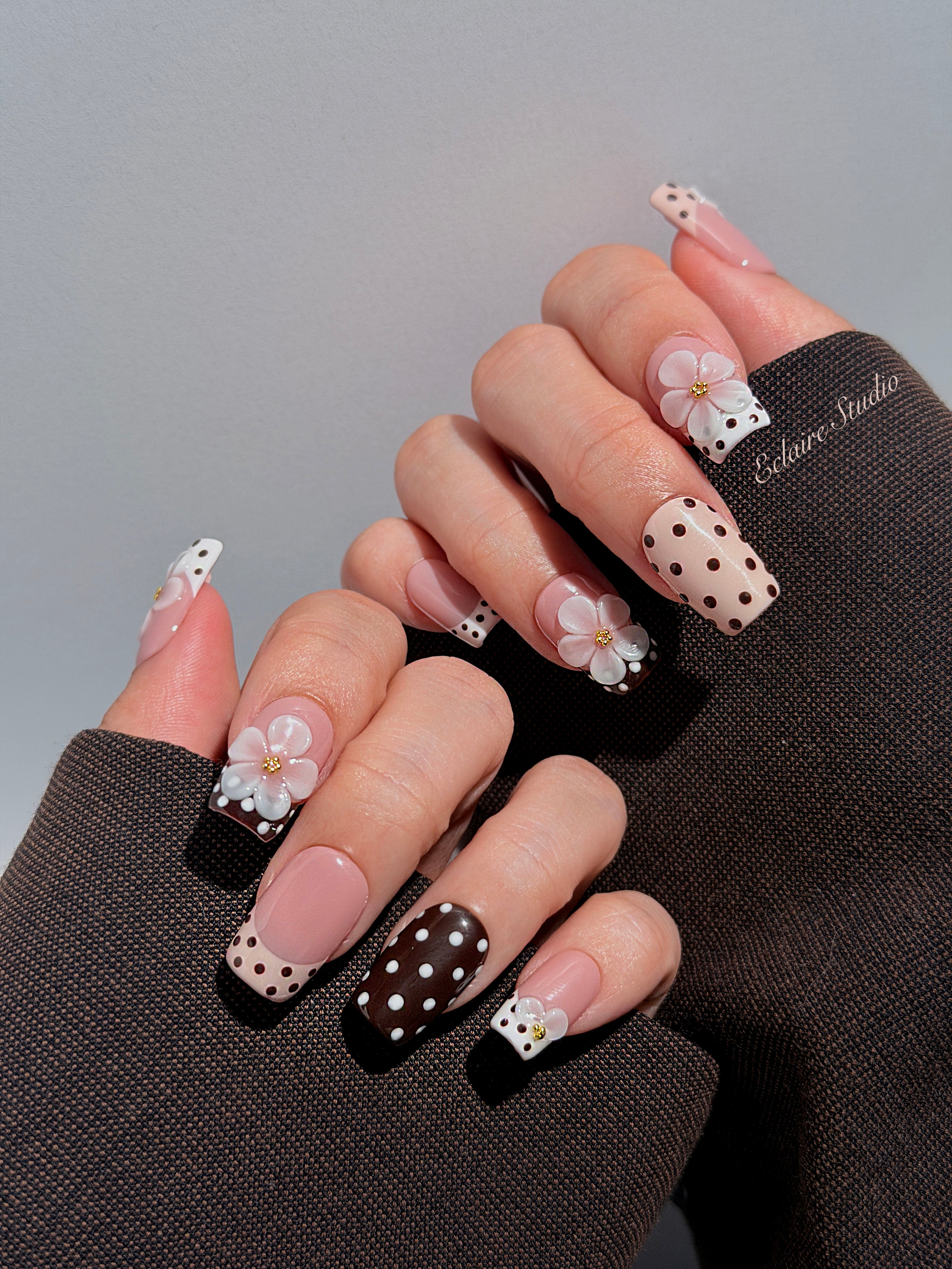 Eclaire Nail Studio 3D Floral Polka dot pink base with alternating black and white polka dot French tips, and hand-sculpted 3D frosted white flowers with gold bead centers, Medium Square