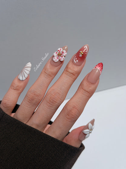 Rouge press-on nails with red linework and 3D white florals on a nude base – Éclaire Studio