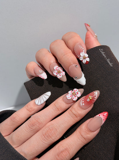 Rouge press-on nails with red linework and 3D white florals on a nude base – Éclaire Studio