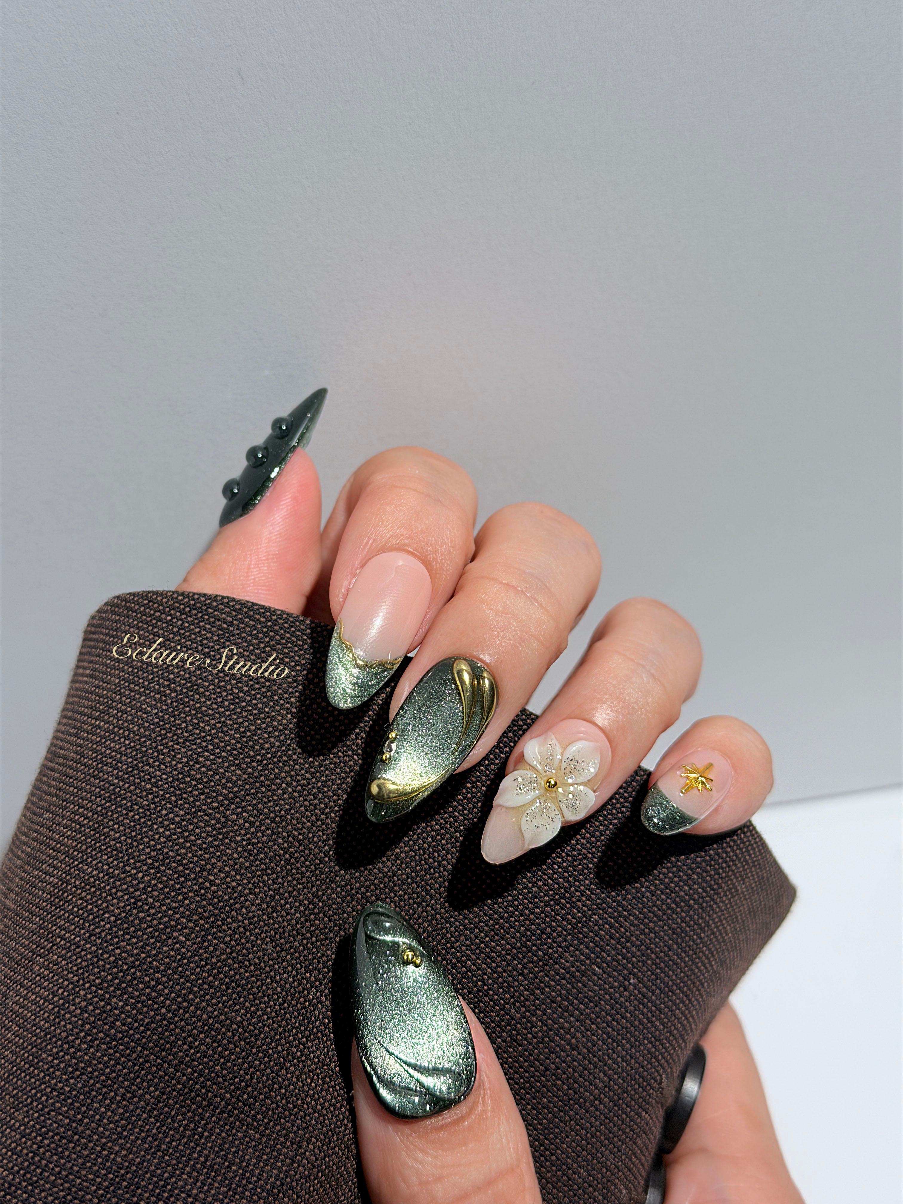Bali Escape almond press-on nails with emerald cat-eye shimmer, 3D frosted flowers and gold accents – Éclaire Studio