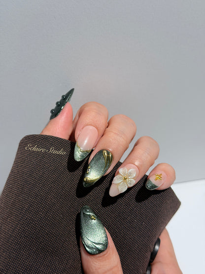 Bali Escape almond press-on nails with emerald cat-eye shimmer, 3D frosted flowers and gold accents – Éclaire Studio