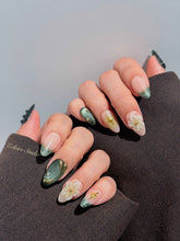 Bali Escape almond press-on nails with emerald cat-eye shimmer, 3D frosted flowers and gold accents – Éclaire Studio