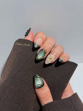 Bali Escape almond press-on nails with emerald cat-eye shimmer, 3D frosted flowers and gold accents – Éclaire Studio