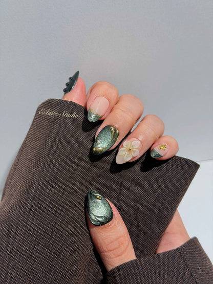 Bali Escape almond press-on nails with emerald cat-eye shimmer, 3D frosted flowers and gold accents – Éclaire Studio