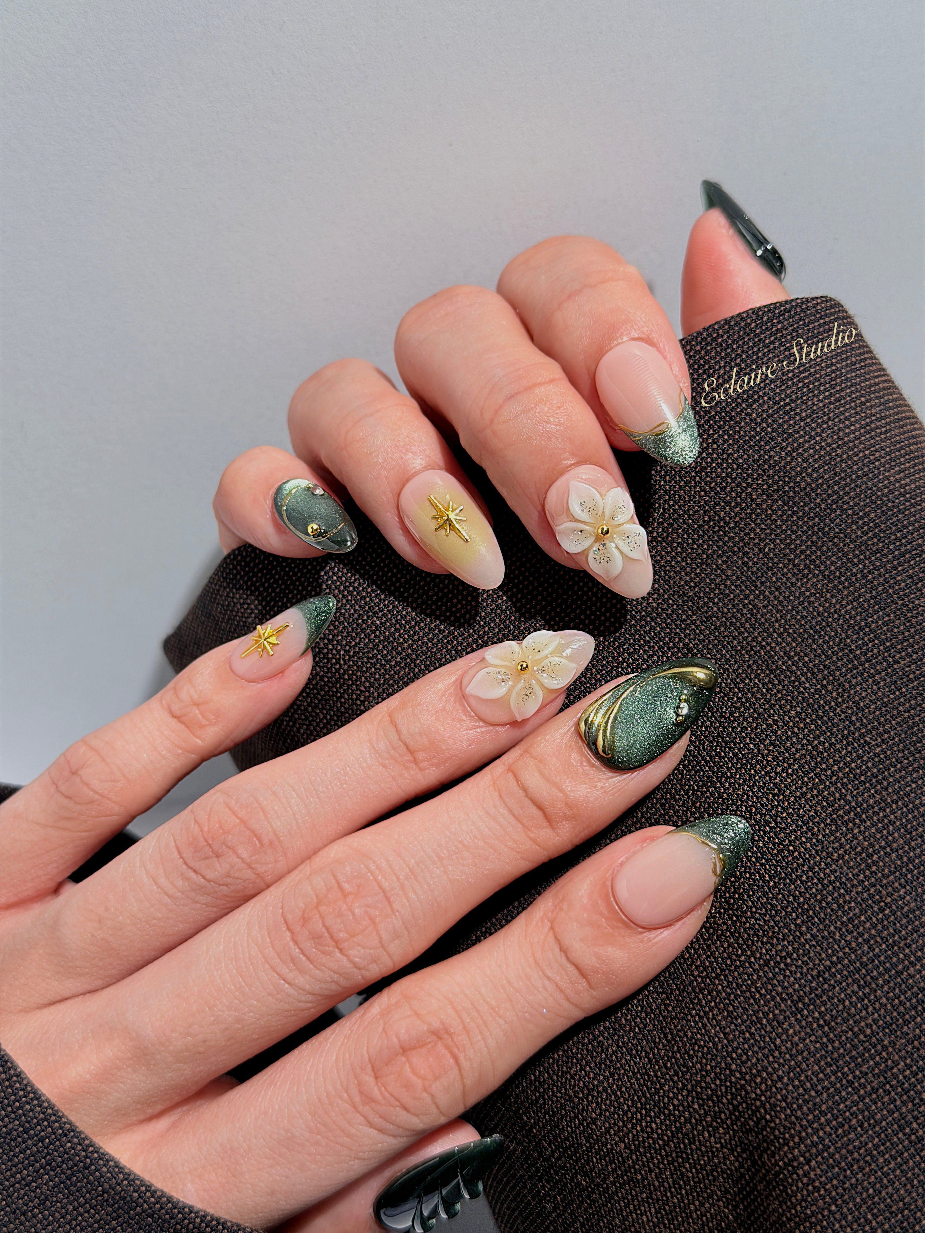 Bali Escape almond press-on nails with emerald cat-eye shimmer, 3D frosted flowers and gold accents – Éclaire Studio