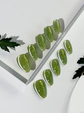 Green cat-eye press-on nails featuring layered ivy designs brushed with shiny green powder — Éclaire Nail Studio