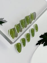 Green cat-eye press-on nails featuring layered ivy designs brushed with shiny green powder — Éclaire Nail Studio