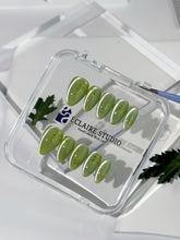 Green cat-eye press-on nails featuring layered ivy designs brushed with shiny green powder — Éclaire Nail Studio