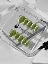 Green cat-eye press-on nails featuring layered ivy designs brushed with shiny green powder — Éclaire Nail Studio