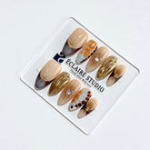 Dune caramel and espresso press-on nails with gold chrome wave, starbursts and opal gem – Éclaire Studio