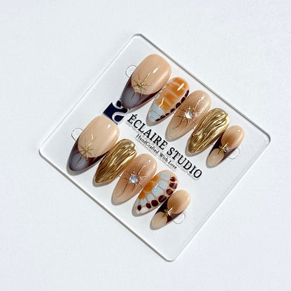 Dune caramel and espresso press-on nails with gold chrome wave, starbursts and opal gem – Éclaire Studio