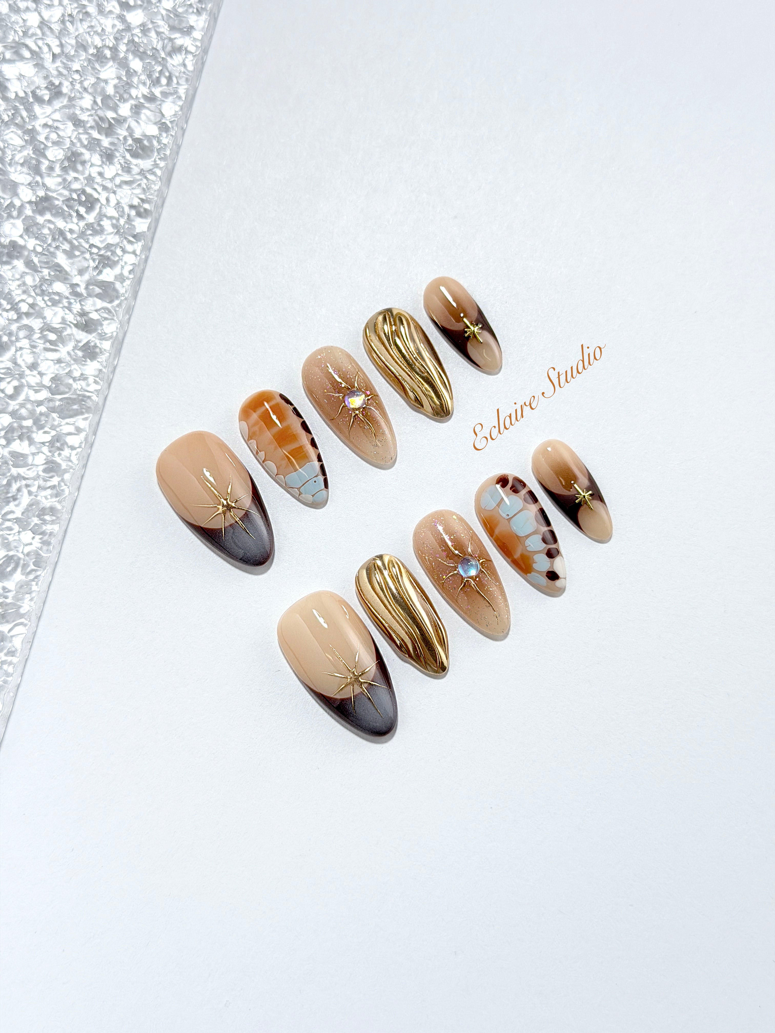 Dune caramel and espresso press-on nails with gold chrome wave, starbursts and opal gem – Éclaire Studio