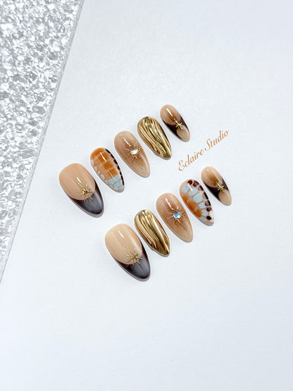 Dune caramel and espresso press-on nails with gold chrome wave, starbursts and opal gem – Éclaire Studio