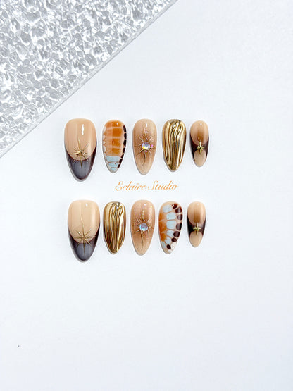 Dune caramel and espresso press-on nails with gold chrome wave, starbursts and opal gem – Éclaire Studio