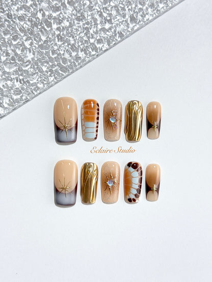 Dune caramel and espresso press-on nails with gold chrome wave, starbursts and opal gem – Éclaire Studio