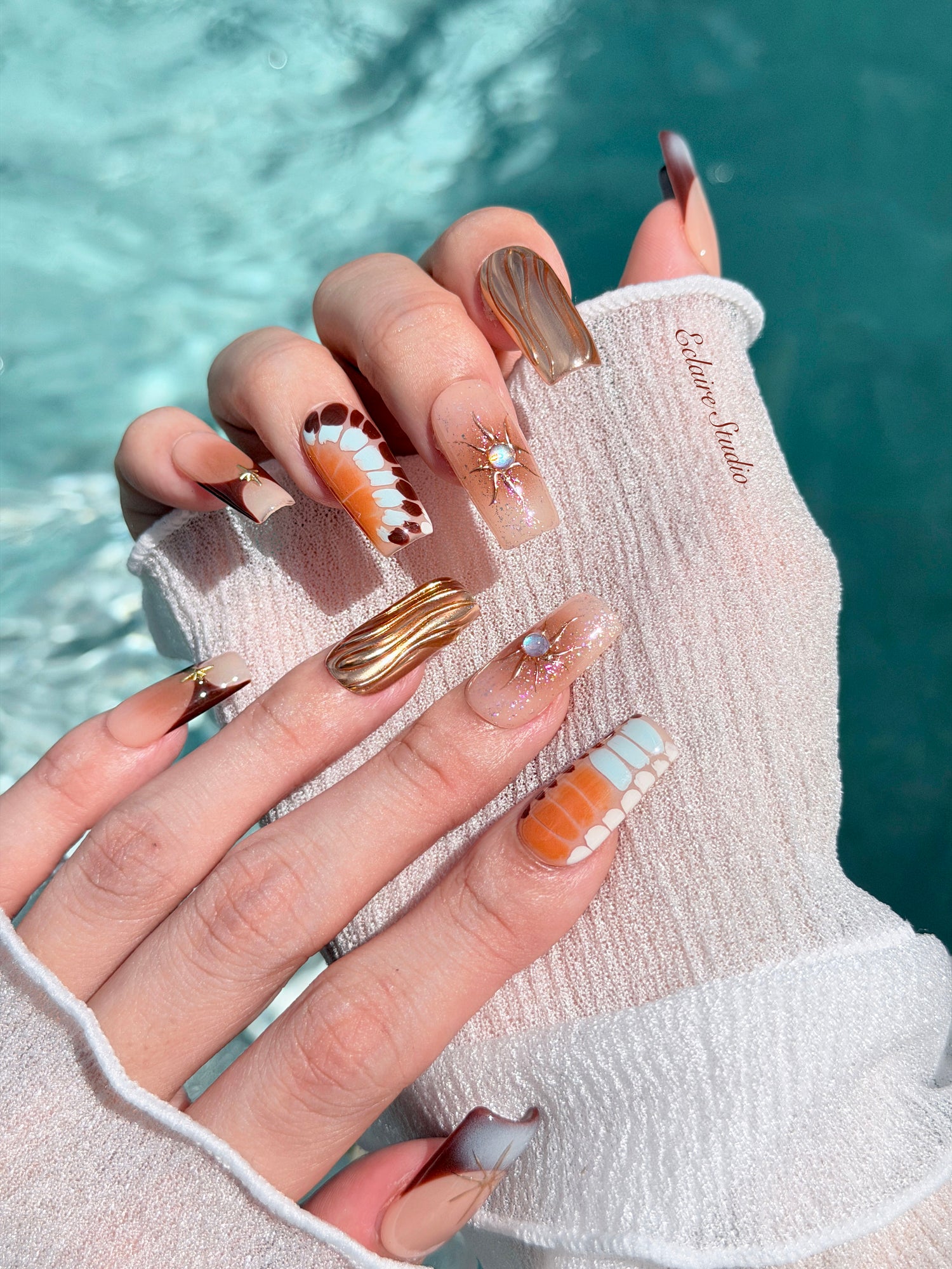 Dune caramel and espresso press-on nails with gold chrome wave, starbursts and opal gem – Éclaire Studio