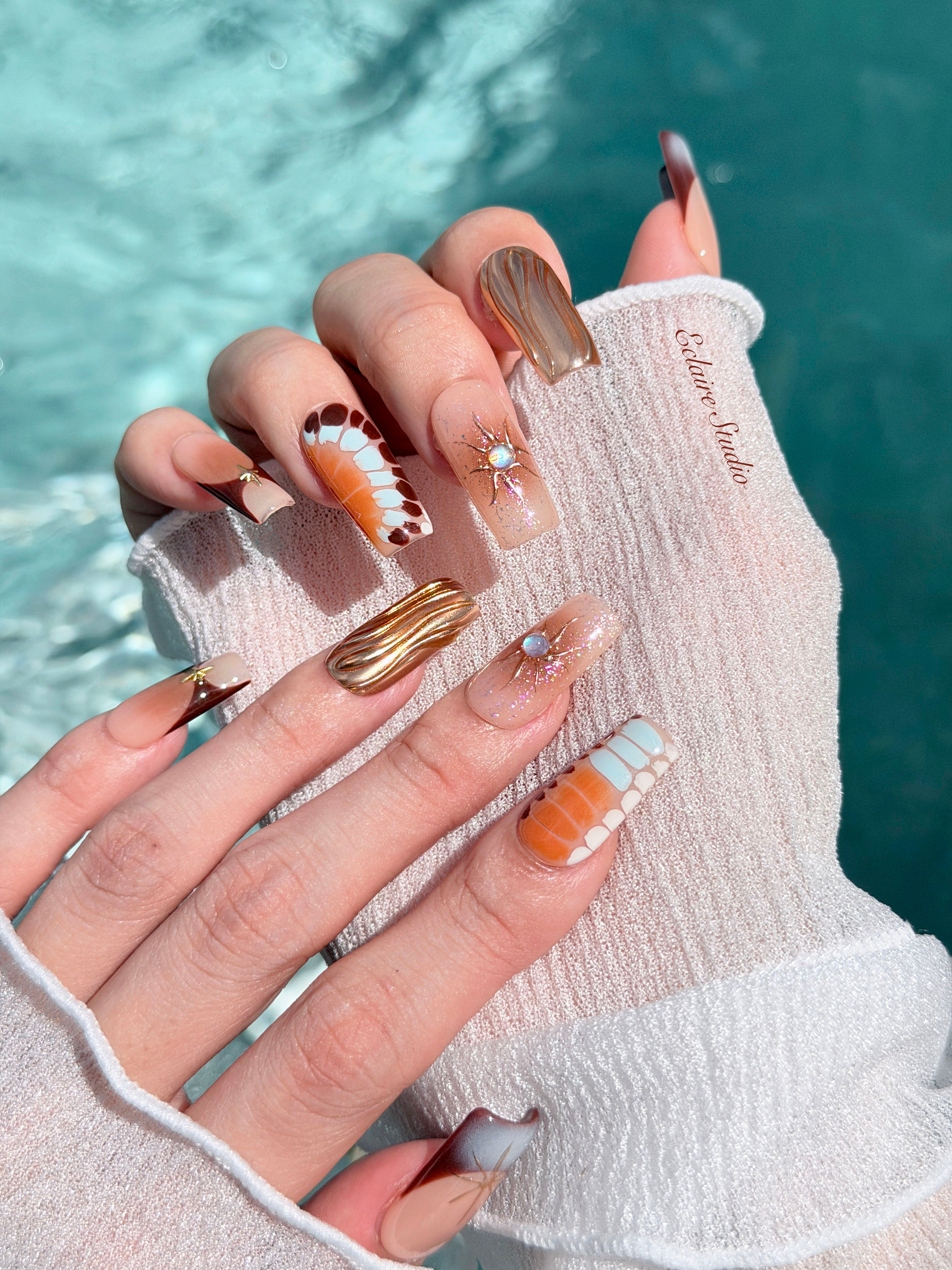 Dune caramel and espresso press-on nails with gold chrome wave, starbursts and opal gem – Éclaire Studio