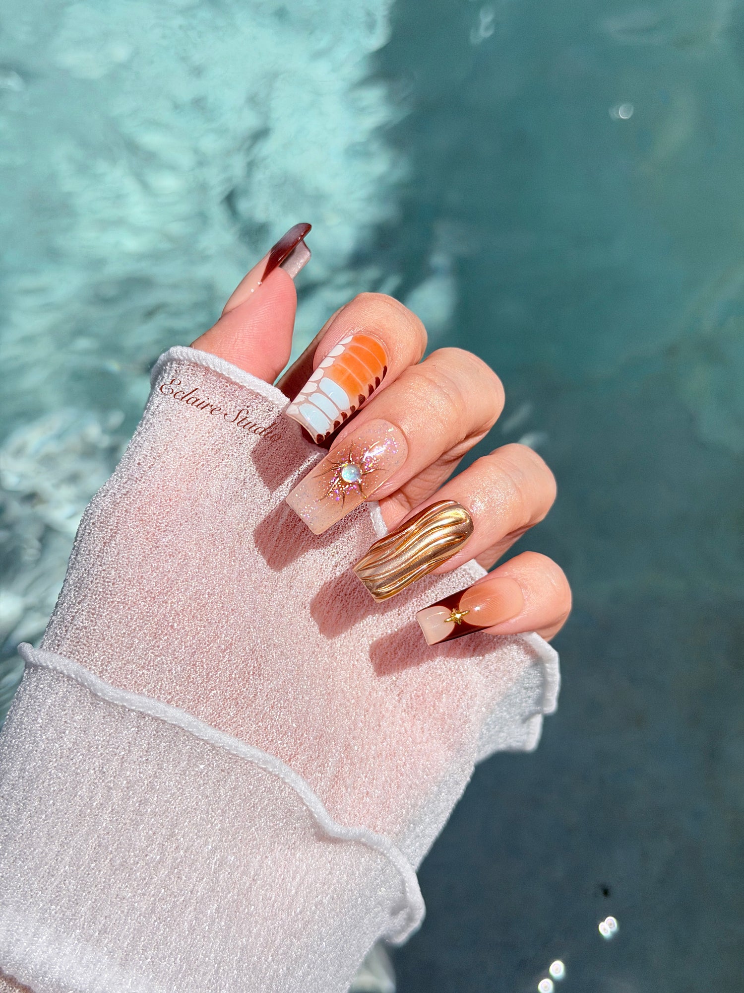 Dune caramel and espresso press-on nails with gold chrome wave, starbursts and opal gem – Éclaire Studio