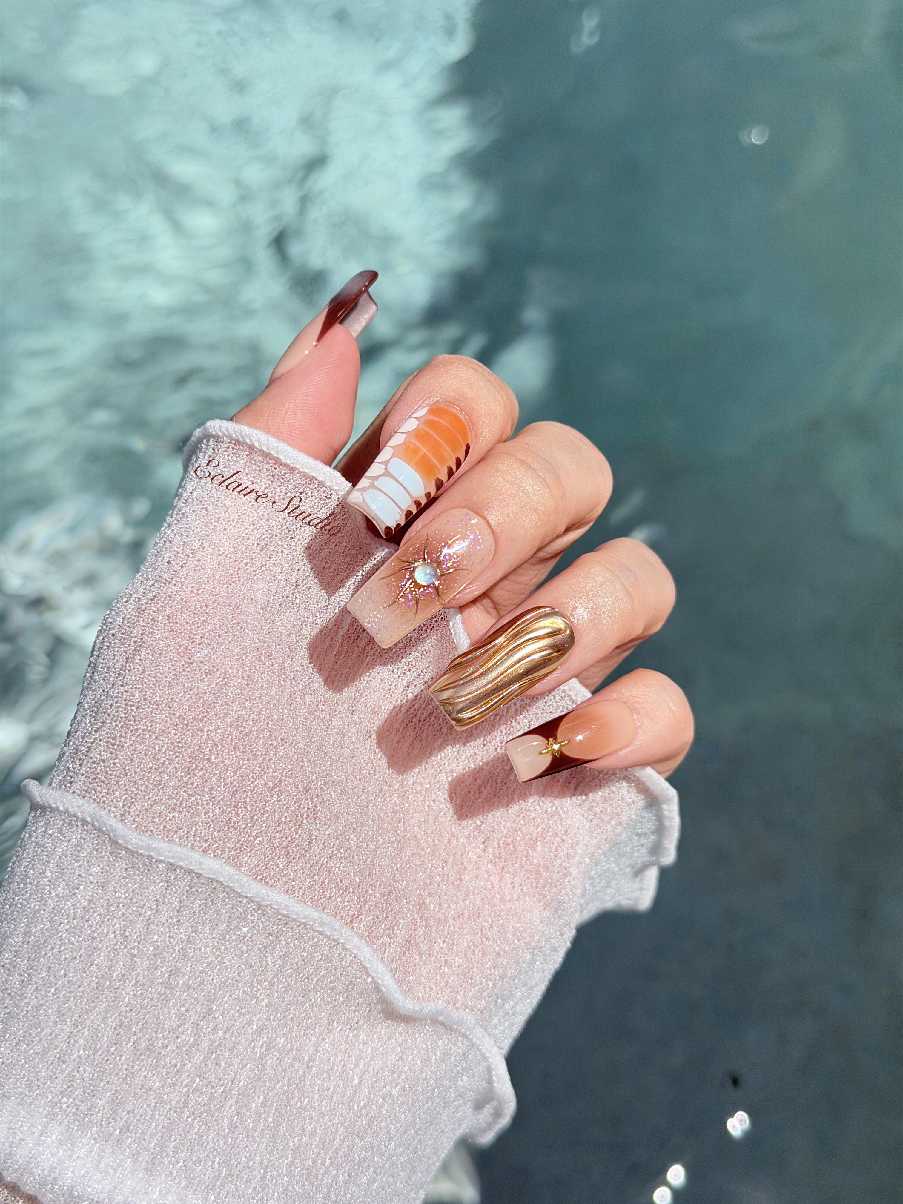Dune caramel and espresso press-on nails with gold chrome wave, starbursts and opal gem – Éclaire Studio